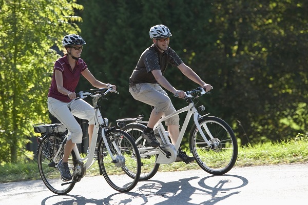 Couple e-biking over a hill