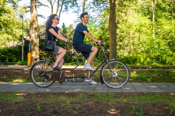 Meisje en jongen fietsen op de tandem door de gemeente Weert