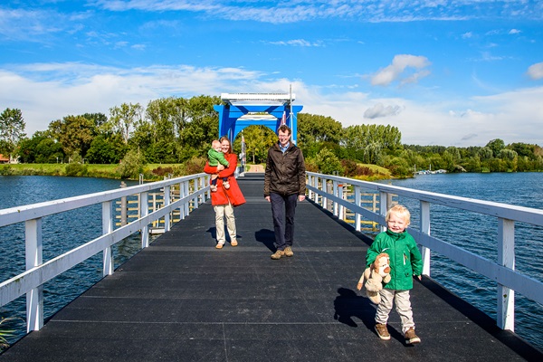 Family walks on the bridge over the Maasplassen in Maasgouw municipality